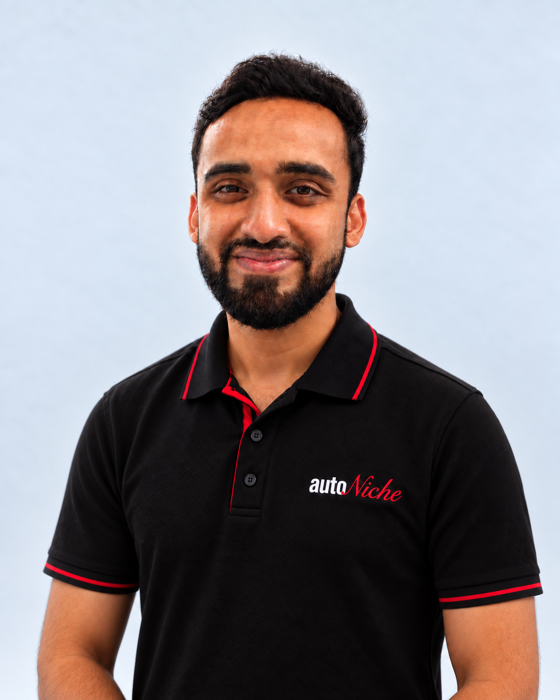 Murtaza, AutoNiche Service Manager, in an AutoNiche polo against a light studio background