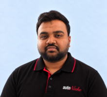 Yasser, AutoNiche Service Advisor, wearing an AutoNiche polo against a pale blue studio background
